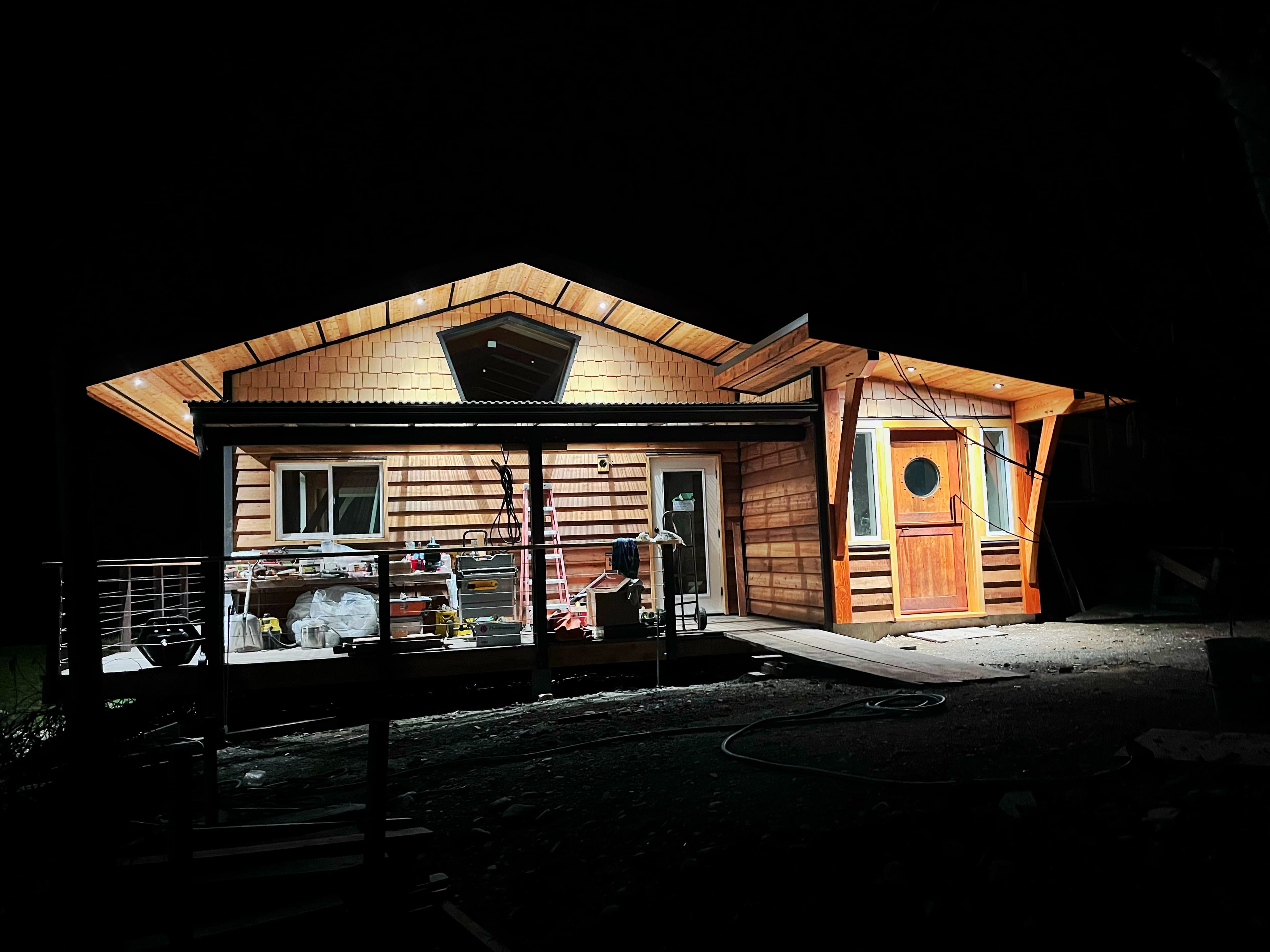 Timber-framed home exterior glowing warmly at night
